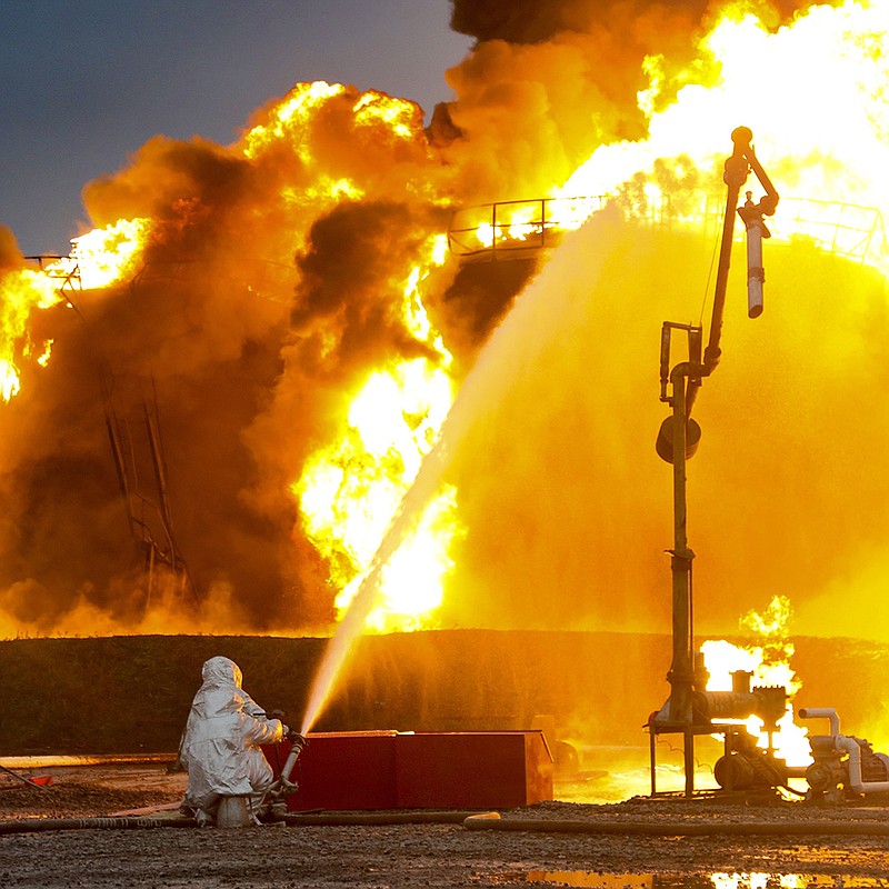 Firefighters in Russia-occupied Shakhtarsk in the Donetsk People’s Republic in eastern Ukraine work to control a huge fire Thursday at an oil depot after shelling by Ukrainian forces. Russian officials said 12 storage tanks were set afire in the overnight attack. More photos at arkansasonline.com/ukrainemonth8/.
(AP)