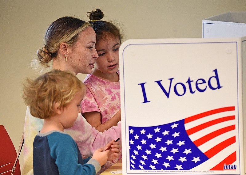 Lauren Byers of Little Rock is joined by her children Harbor, 7, and Crew, 5, as she fills out a ballot Friday during early voting at the Hillary Rodham Clinton Children’s Library in Little Rock.
(Arkansas Democrat-Gazette/Staci Vandagriff)