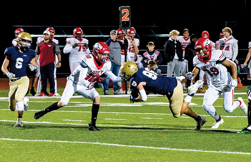 Trey Bexten of Helias lunges forward for extra yards during Friday night’s game against Liberty: Wentzville at Ray Hentges Stadium. (Ken Barnes/News Tribune)