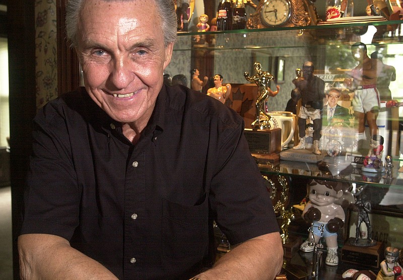 FILE — Boxing coach Ray Rodgers in front a glass case of boxing memorabalia at his home in Little Rock in this July 19, 2002 file photo.