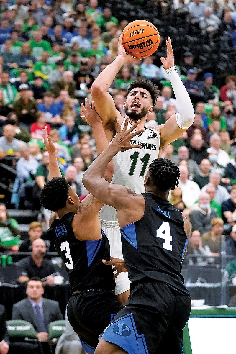 In this Dec. 1, 2021, file photo, Utah Valley center Fardaws Aimaq shoots over a pair of BYU defenders during a game in Orem, Utah. Aimaq ended up transferring to Texas Tech in the hopes of raising his NBA Draft profile this season. (Associated Press)