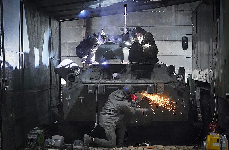 Ukrainian National Guard soldiers repair a captured Russian armored personnel carrier Thursday at a shop on the outskirts of Kharkiv in northern Ukraine. Officials said Thursday that 868 bodies of civilians, including 24 children, were found in liberated areas of the Kharkiv, Donetsk and Kherson regions. More photos at arkansasonline.com/ukrainemonth9/.
(AP/Andrii Marienko)