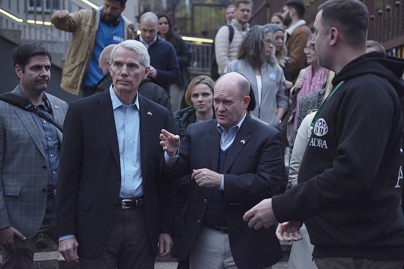 Sen. Rob Portman (left) and Sen. Chris Coons meet with hard-hit Ukrainian families Thursday at a distribution center in Kyiv.
(AP/Andrew Kravchenko)