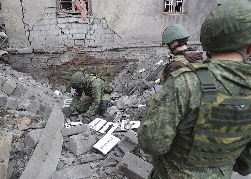 Russian soldiers inspect the scene at an apartment building after shelling Friday by Ukrainian forces in Makiivka in the Donetsk People’s Republic in eastern Ukraine.
(AP)