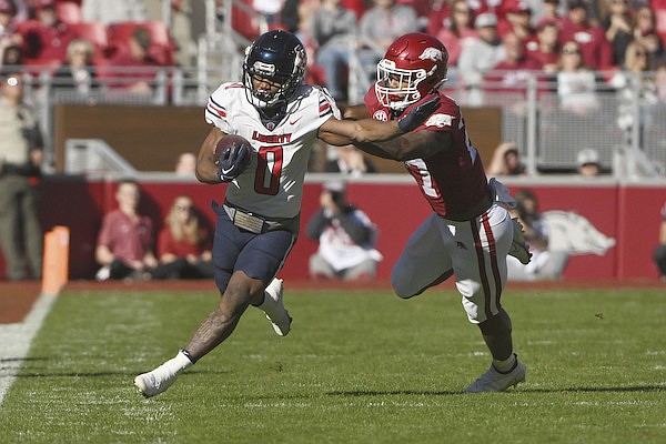 Liberty running back Dae Dae Hunter (0) is knocked out of bounds by Arkansas linebacker Chris Paul Jr., right, during the first half of an NCAA college football game Saturday, Nov. 5, 2022, in Fayetteville. (AP Photo/Michael Woods)