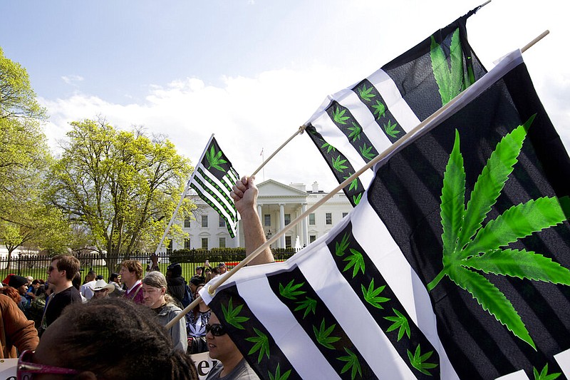 FILE - A demonstrator waves a flag with marijuana leaves depicted on it during a protest calling for the legalization of marijuana, outside of the White House on April 2, 2016, in Washington. Voters in five states are deciding on Nov. 8, 2022 Election Day whether to approve recreational marijuana. The proposals are going before voters in Arkansas, Maryland, Missouri, North Dakota and South Dakota. (AP Photo/Jose Luis Magana, File)