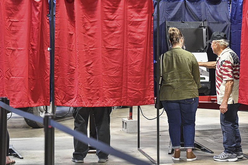 Bob Spaulding (right), a poll worker, assist a voter inside a voting booth, Tuesday, Nov. 8, 2022, at the Crawford County Emergency Operations Center in Van Buren. (NWA Democrat-Gazette/Hank Layton)