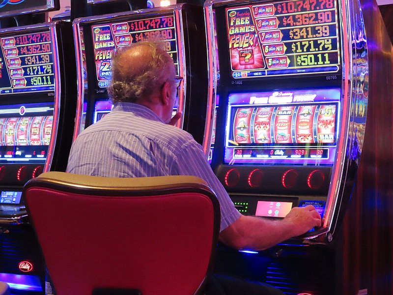 A gambler plays a slot machine at the Hard Rock Casino in Atlantic City, N.J., on Aug. 8, 2022. Figures released on Nov. 9, 2022, by the American Gaming Association show the U.S. commercial casino industry had its best quarter ever, taking in $15 billion from gamblers in the third quarter of the year. (AP/Wayne Parry)