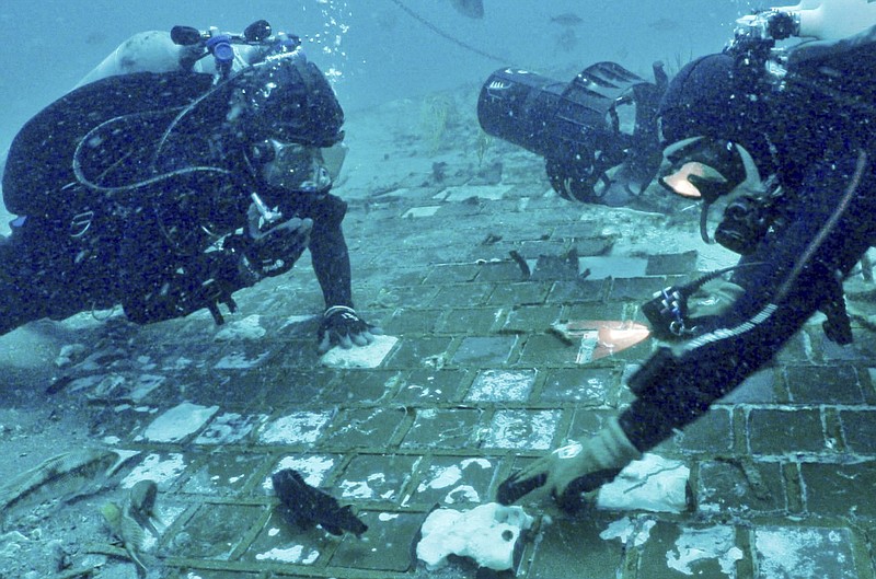 In this photo provided by The History Channel, underwater explorer and marine biologist Mike Barnette and wreck diver Jimmy Gadomski explore a 20-foot segment of the 1986 Space Shuttle Challenger that the team discovered in the waters off the coast of Florida during the filming of The History Channel’s new series, “The Bermuda Triangle: Into Cursed Waters,” premiering Tuesday, Nov. 22, 2022. (The History® Channel via AP)