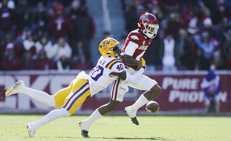 LSU linebacker Harold Perkins (40) tackles Arkansas quarterback Malik Hornsby, forcing a fumble during the second quarter Saturday at Reynolds Razorback Stadium in Fayetteville. Perkins had eight tackles and four sacks as the No. 7 Tigers won 13-10 to claim the Golden Boot Trophy. More photos at arkansasonline.com/1113lsuua/
(NWA Democrat-Gazette/Charlie Kaijo)