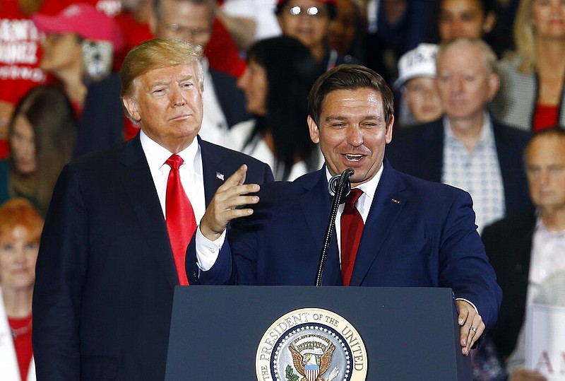FILE- In this Nov. 3, 2018 file photo President Donald Trump stands behind gubernatorial candidate Ron DeSantis at a rally in Pensacola, Fla. (AP/Butch Dill, File)