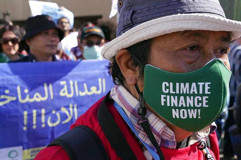 A protester wears a mask that reads "climate finance now!" at the COP27 U.N. Climate Summit, Saturday, Nov. 12, 2022, in Sharm el-Sheikh, Egypt. (AP/Peter Dejong)