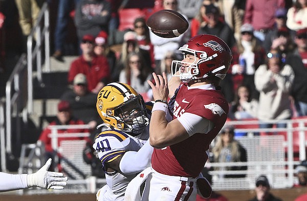LSU linebacker Harold Perkins Jr. (40) knocks the ball away from Arkansas quarterback Cade Fortin (10) during the second half of an NCAA college football game Saturday, Nov. 12, 2022, in Fayetteville. The play was called a fumble and recovery by LSU but was reversed after officials reviewed the play. (AP Photo/Michael Woods)