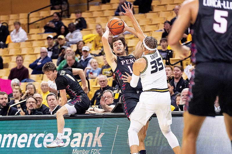Clark Slajchert climbs back over the scorer’s table as Penn teammate Max Martz throws a pass against the defense of Missouri’s Noah Carter during Friday night’s game at Mizzou Arena in Columbia. (Associated Press)