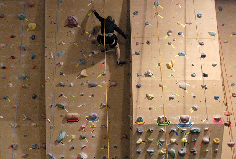 Mike Snodgrass reaches over to grab another rock while scaling a climbing wall in Little Rock in this Dec. 20, 2007 file photo. (Arkansas Democrat-Gazette file photo)