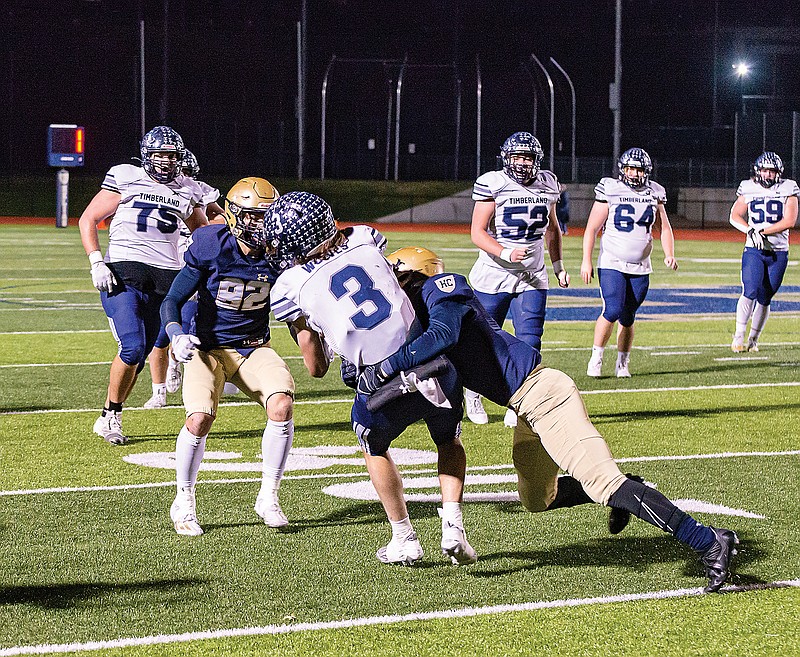 Helias linebacker Logan Montoya wraps up Timberland quarterback A.J. Raines during Friday night’s game at the Crusader Athletic Complex. (Ken Barnes/News Tribune)