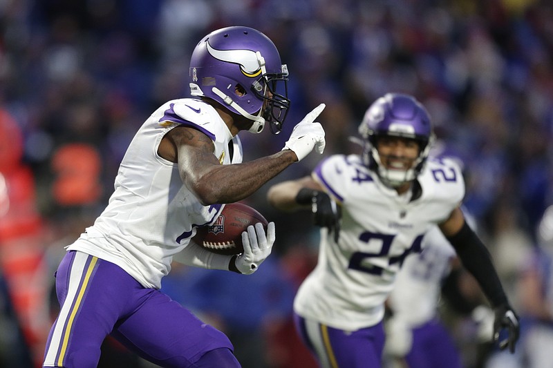 Minnesota Vikings cornerback Patrick Peterson (7) runs with the ball after incepting a pass by Buffalo Bills quarterback Josh Allen as safety Camryn Bynum (24) looks on in overtime of an NFL football game, Sunday, Nov. 13, 2022, in Orchard Park, N.Y. (AP Photo/Joshua Bessex)