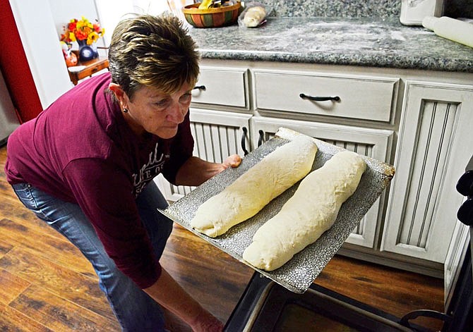 Cindy DeOrnellis places bread dough in the oven. She said she likes to use simple ingredients and mainly sticks to yeast-based breads.
