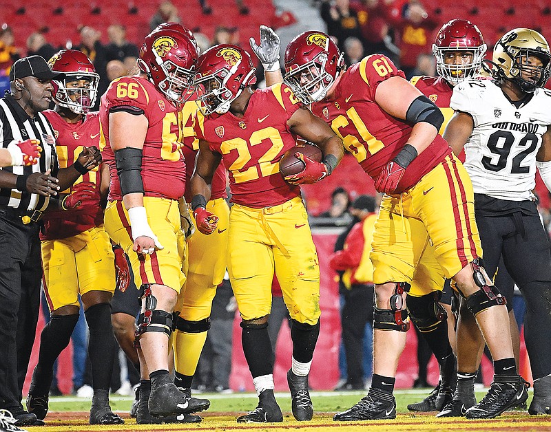 Southern California running back Darwin Barlow (22) is congratulated by offensive linemen Gino Quinones (66) and Joe Bryson (61) after scoring a touchdown in the fourth quarter of last Friday night's game against Colorado in Los Angeles. (Associated Press)