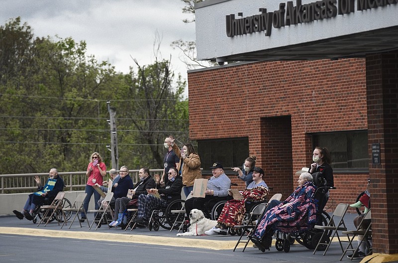 Veterans wave as a parade goes by the Arkansas State Veterans Home in Fayetteville in this April 19, 2020 file photo. (NWA Democrat-Gazette/Charlie Kaijo)