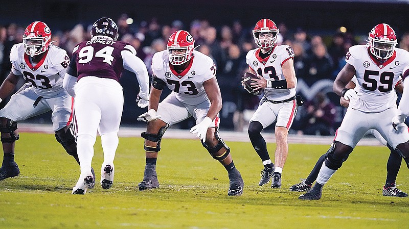 Georgia quarterback Stetson Bennett sets up to pass behind the pass protection of offensive linemen Sedrick Van Pran (63), Xavier Truss (73) and Broderick Jones (59) while Mississippi State defensive tackle Jaden Crumedy rushes during last Saturday's game in Starkville, Miss. (Associated Press)