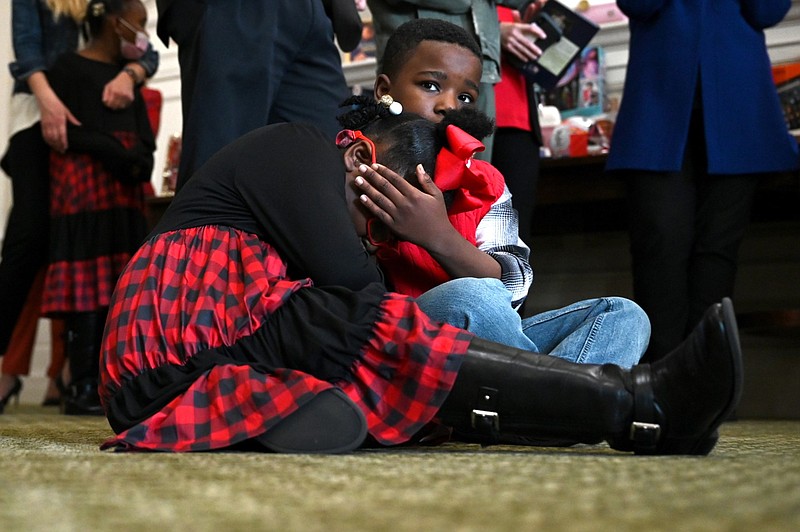 Antonia Johnson and Kenji Dabbs, then ages 7 and 10 respectively, snuggle on the floor of the Old Supreme Court room as they wait to open their presents during Christmas at the Capitol in this Dec. 6, 2021 file photo. The annual event helps children under the care of the Arkansas Division of Children and Family Services have a good Christmas with presents. (Arkansas Democrat-Gazette/Stephen Swofford)