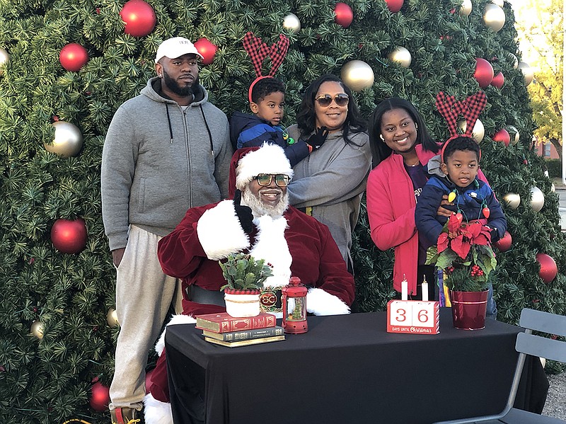 Chris Kennedy, dressed as Santa Claus, poses for a photo with members of the Heaggans family at the annual Northern Lights Festival in the Argenta neighborhood of North Little Rock on Saturday.
(Arkansas Democrat-Gazette/Daniel McFadin)