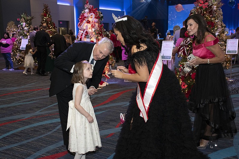 Skyler Long  prepares to place a princess crown on Charlotte Anne Griffin, as her father, Lt. Gov. Tim Giffin watches on 11/3/2022 at Carti's Sugar Plum Bell held in the Wally Allen Ballroom of the Statehouse Convention Center.
(Arkansas Democrat-Gazette/Cary Jenkins)