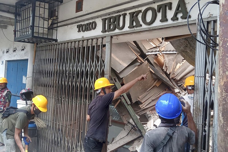 Workers inspect a store damaged during an earthquake in Cianjur, West Java, Indonesia, Monday, Nov. 21, 2022. (AP/Firman Taqur)