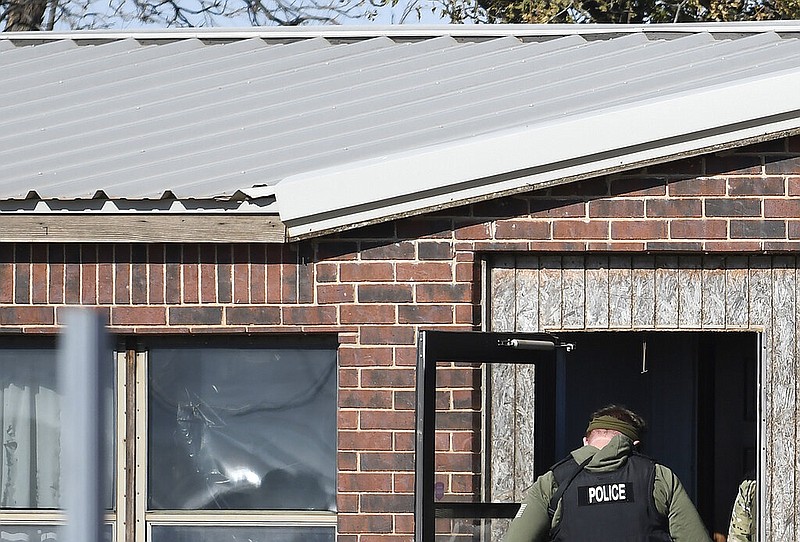 A law enforcement officer enters a residence near Lacey, Okla., in Kingfisher County, Monday, Nov. 21, 2022, the was the scene of a quadruple homicide. State police in Oklahoma say that four people killed at a marijuana farm were "executed," and that they were Chinese citizens. (Billy Hefton/The Enid News & Eagle via AP)