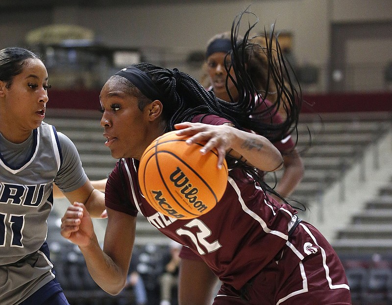 UALR guard Tia Harvey (12) drives to the basket Wednesday while guarded by Oral Roberts guard Ariel Walker during the Trojans’ 74-62 loss at the Jack Stephens Center in Little Rock. More photos at arkansasonline.com/1124ualr/.
(Arkansas Democrat-Gazette/Thomas Metthe)