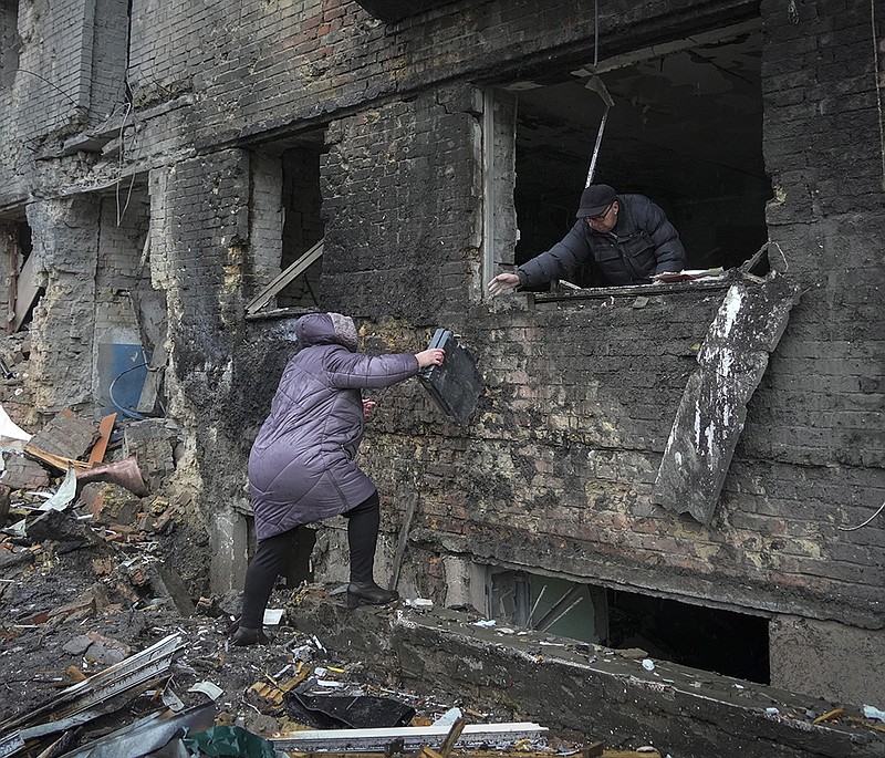 People gather their belongings from a damaged house Thursday after Russian shelling in the town of Vyshgorod outside the capital Kyiv, Ukraine. More photos at arkansasonline.com/1125kyiv/.
(AP/Efrem Lukatsky)
