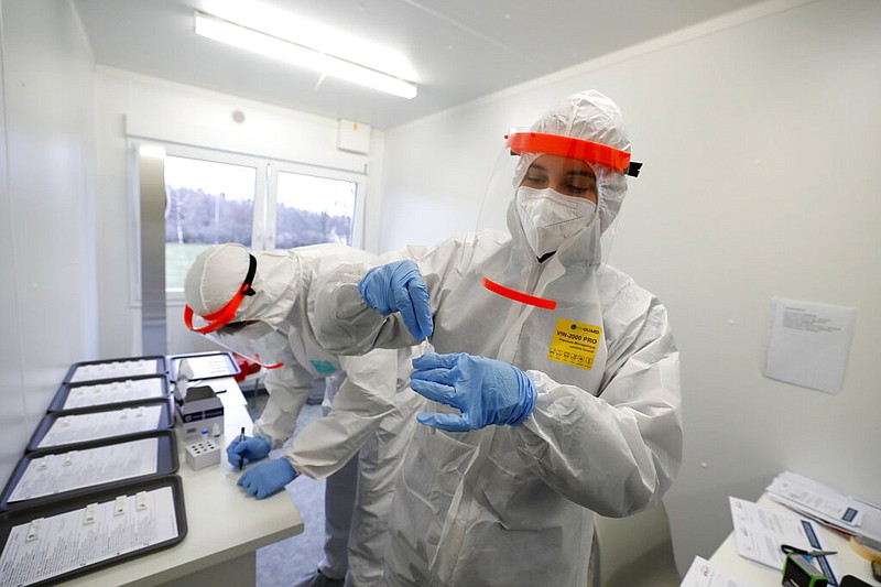 Medical workers examine rapid antigen tests for covid-19, the coronavirus, in Prague, Czech Republic, in this Dec. 16, 2020 file photo. (AP/Petr David Josek)