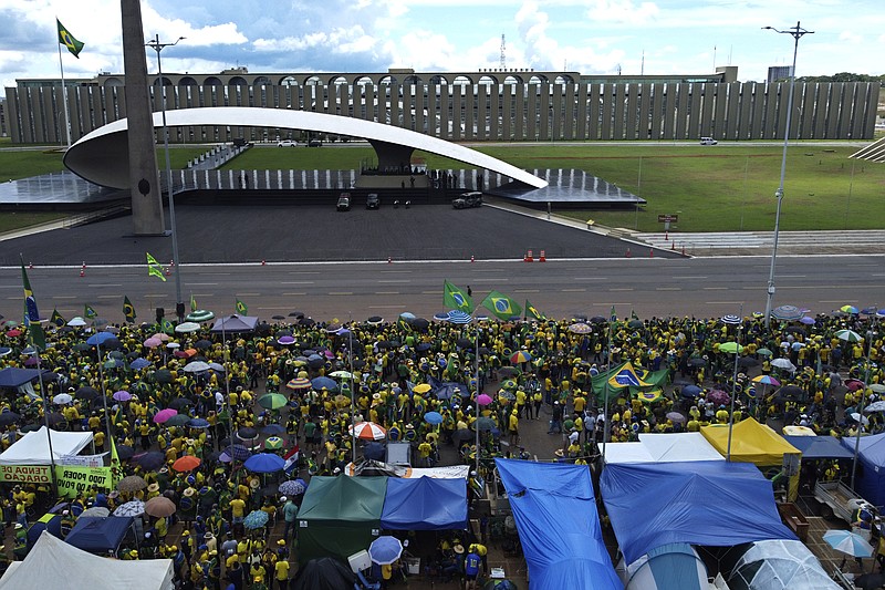 FILE - Supporters of Brazilian President Jair Bolsonaro protest against Bolsonaro's run-off election loss outside the Army headquarters in Brasilia, Brazil, Nov. 15, 2022. Supporters of incumbent President Jair Bolsonaro who refuse to accept his narrow defeat in October’s election have blocked roads and camped outside military buildings while pleading for intervention from the armed forces or marching orders from their commander in chief. (AP Photo/Eraldo Peres, File)