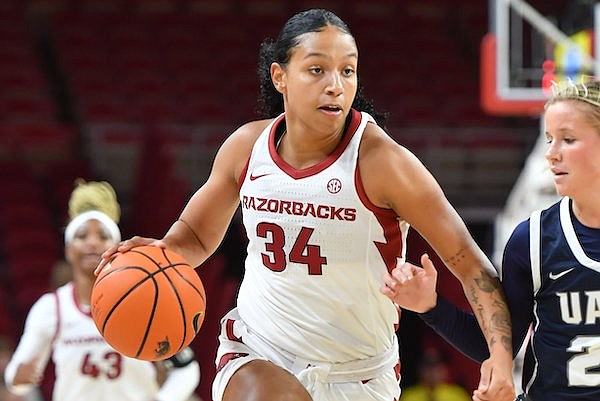 Arkansas guard Chrissy Carr (34) drives with the basketball Wednesday, Nov. 2, 2022, as Arkansas-Fort Smith guard Riley Hayes (25) defends during the first half of play in Bud Walton Arena in Fayetteville.