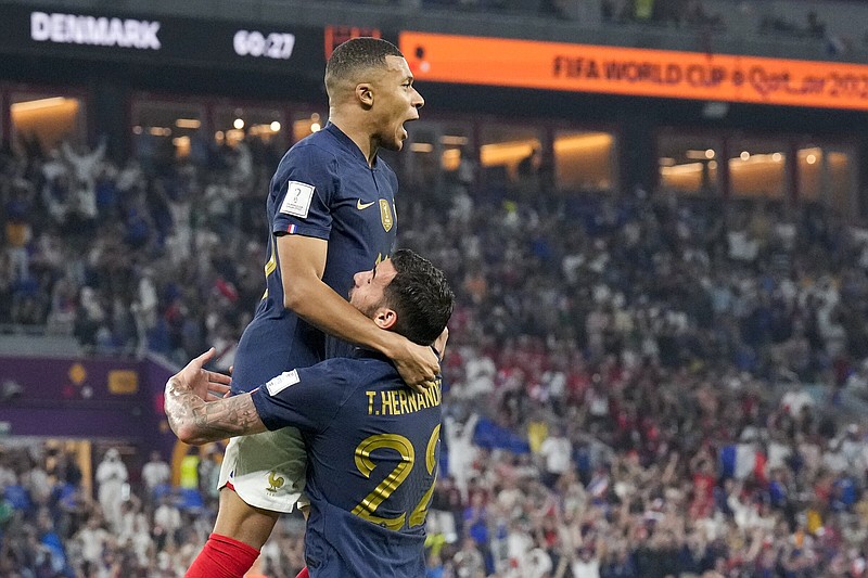 France’s Kylian Mbappe (left) celebrates with teammate Theo Hernandez after giving his team a 1-0 lead against Denmark in the first half Saturday in Doha, Qatar. Mbappe scored both of France’s goals in a 2-1 win. More photos at arkansasonline.com/1127wcup22/
(AP/Martin Meissner)