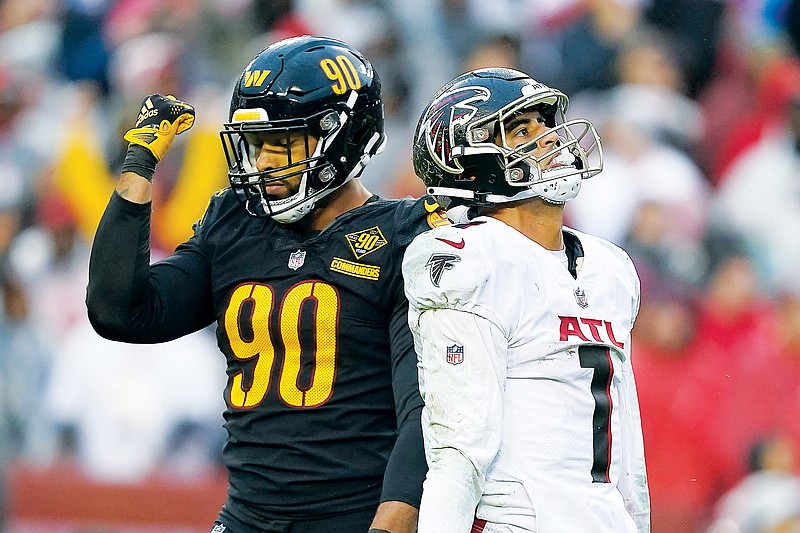 Commanders defensive end Montez Sweat and Falcons quarterback Marcus Mariota react to an interception thrown by Mariota during Sunday’s game in Landover, Md. (Associated Press)