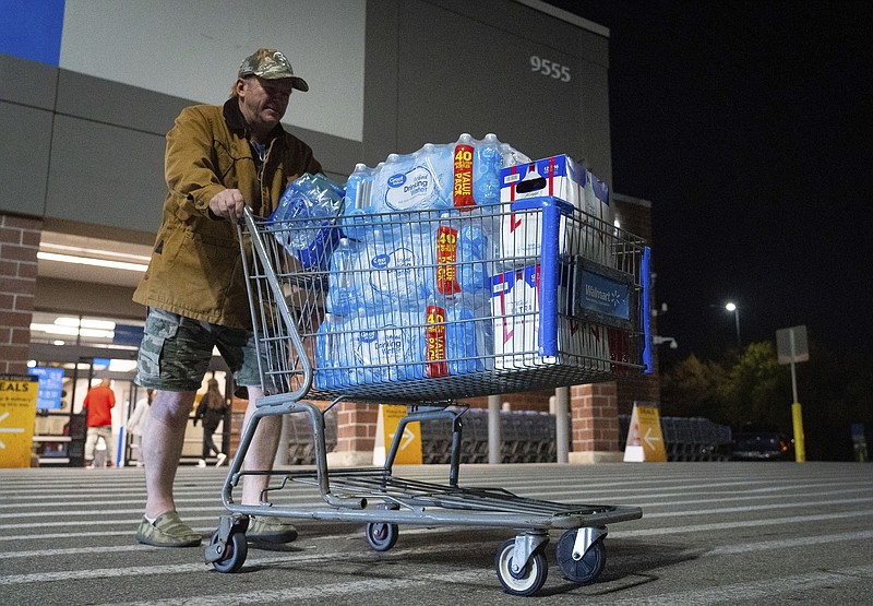 John Beezley, of Bonham, carts out several cases of water after learning that a boil water notice was issued for the entire city of Houston on Sunday, Nov. 27, 2022, at Walmart on S. Post Oak Road in Houston. (Mark Mulligan/Houston Chronicle via AP)
