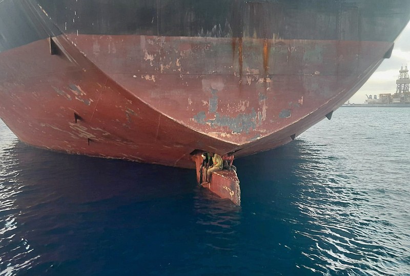 In this photo released by Spain's Maritime Safety and Rescue Society on Tuesday Nov. 29, 2022, three men are photographed on an oil tanker anchored in the port of the Canary Islands, Spain. Spain’s Maritime Rescue Service says it has rescued three stowaways traveling on a ship’s rudder in the Canary Islands after the vessel sailed there from Nigeria. The men were found on the Alithini II oil tanker at the Las Palmas port. (Salvamento Maritimo via AP)