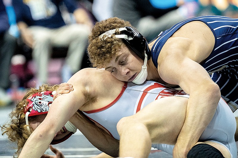Carter Prenger of Helias works to flip St. Clair’s Creek Hughes during their first-round match at 120 pounds in the Class 2 state tournament earlier this year at Mizzou Arena in Columbia. (News Tribune file photo)