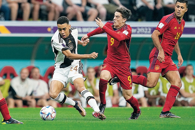 Germany’s Karim Adeyemi and Spain’s Gavi vie for the ball Sunday during a World Cup Group E match in Al Khor, Qatar. (Associated Press)