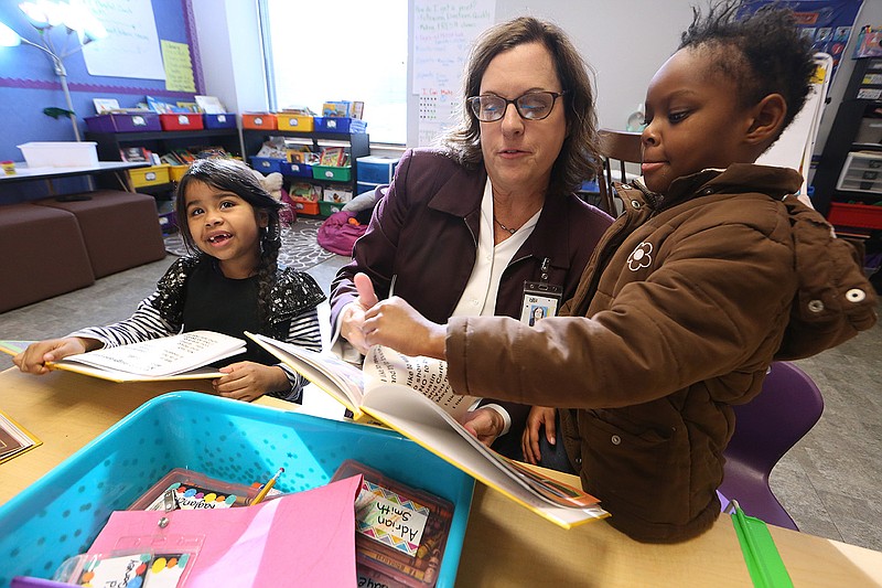 Debbie Higgins, coordinator of secondary math for the North Little Rock School District, reads the “I Like Me” books to kindergartners Maycee Ragland (right) and Emily Vasquez-Paisano on Thursday at Boone Park Elementary School in North Little Rock.
(Arkansas Democrat-Gazette/Thomas Metthe)