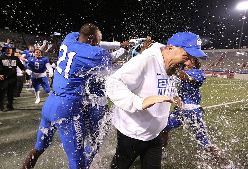 Bryant Coach Buck James gets a celebratory ice bath from several Hornets players at the end of the Class 7A state championship game against Bentonville on Friday night at War Memorial Stadium in Little Rock. The Hornets won 36-7 and earned their fifth state title in a row. More photos at arkansasonline.com/123state7a/
(Arkansas Democrat-Gazette/Thomas Metthe)