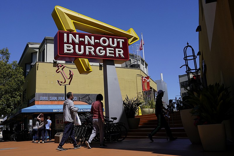 File - People walk below an In-N-Out Burger restaurant sign in San Francisco, Thursday, Aug. 25, 2022. (AP Photo/Jeff Chiu, File)