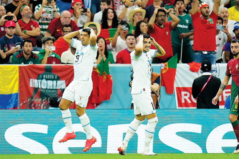 Uruguay teammate Luis Suarez (left) and Maxi Gomez react after a missed chance to score Monday during a World Cup Group H match against Portugal in Lusail, Qatar. (Associated Press)