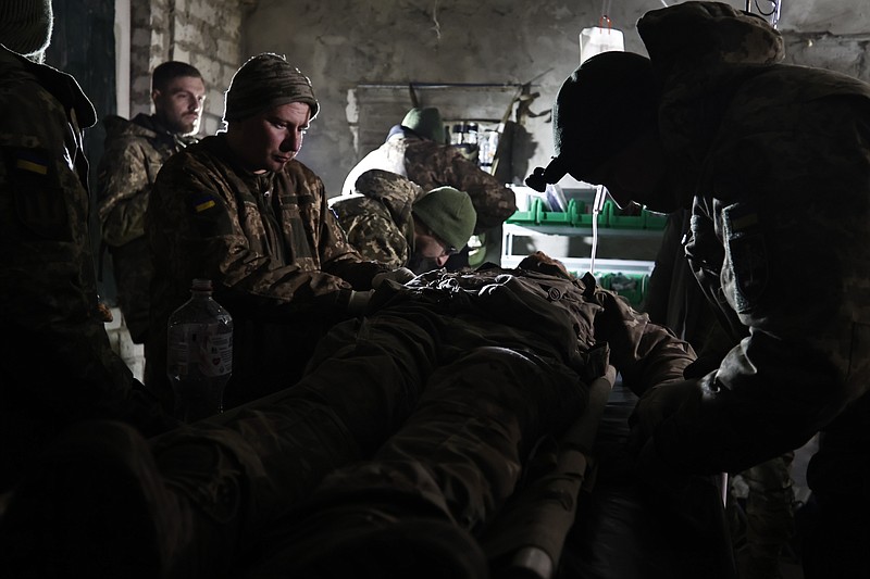 Ukrainian servicemen give the first aid to a soldier wounded in a battle with the Russian troops in their shelter in the Donetsk region, Ukraine, Thursday, Dec. 1, 2022. A top adviser to Ukraine's president has cited military chiefs as saying 10,000 to 13,000 Ukrainian soldiers have been killed in the country's nine-month struggle against Russia's invasion, a rare comment on such figures and far below estimates of Ukrainian casualties from Western leaders. Late Thursday, Dec. 1, 2022, Mykhailo Podolyak, a top adviser to Ukrainian President Volodymyr Zelenskyy, relayed new figures about Ukrainian soldiers killed in battle, while noting that the number of injured troops was higher and civilian casualty counts were â€œsignificant.â€ (AP Photo/Roman Chop)