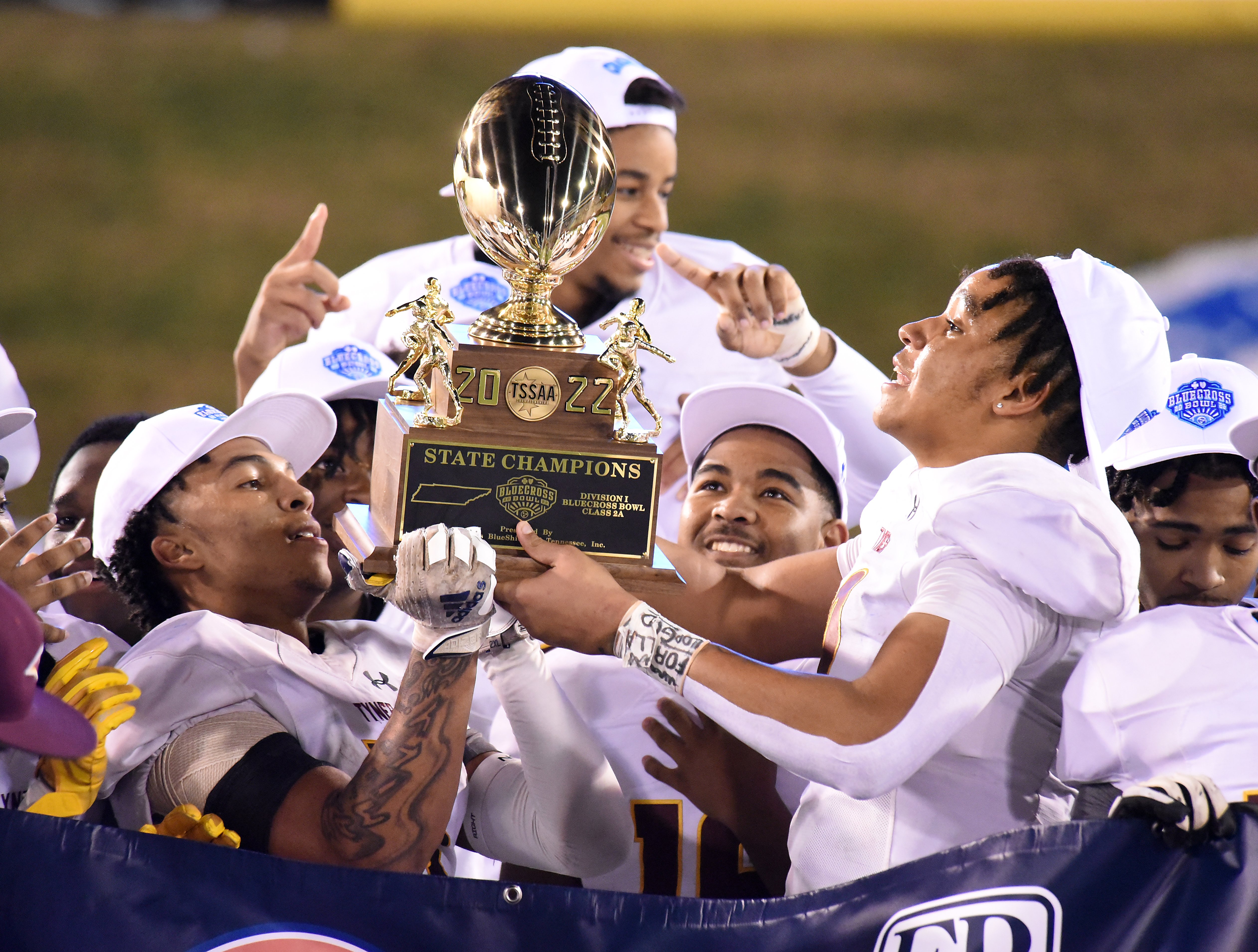 Staff Photo by Matt Hamilton / Tyner players hold the championship trophy after winning the Class 2A BlueCross Bowl state championship game at Finley Stadium on Saturday, December 3, 2022.