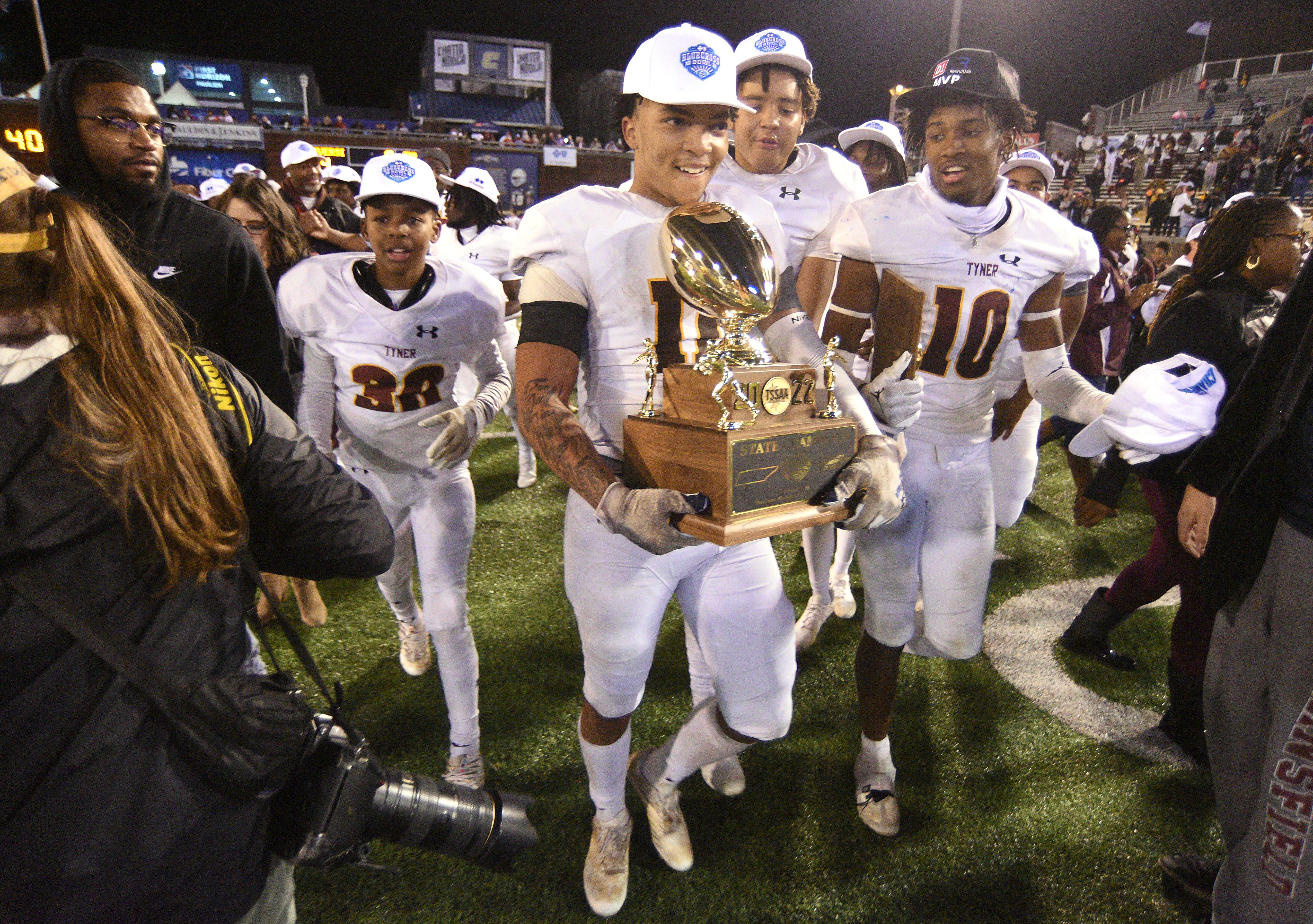 Staff Photo by Matt Hamilton / Tyner (11) Travis Ruffin carries the championship trophy across the field with teammates after winning the Class 2A BlueCross Bowl state championship game at Finley Stadium on Saturday, December 3, 2022.