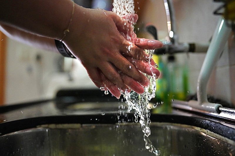 Associated Press reporter Zen Soo washes her hands at a sink in Hong Kong in this April 17, 2020 file photo. (AP/Vincent Yu)