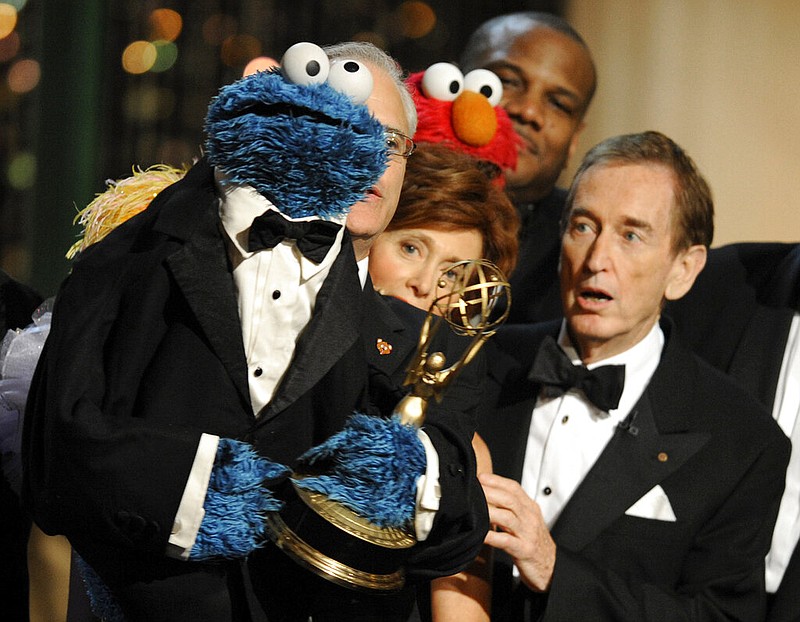 Bob McGrath (right) looks at Cookie Monster as the cast of "Sesame Street" accepts the Lifetime Achievement Award at the Daytime Emmy Awards in Los Angeles in this Aug. 30, 2009 file photo. McGrath, an actor, musician and children’s author widely known for his portrayal of one of the first regular characters on the children’s show “Sesame Street,” has died at the age of 90. McGrath’s passing was confirmed by his family, who posted on his Facebook page on Sunday, Dec. 4, 2022. (AP/Chris Pizzello)
